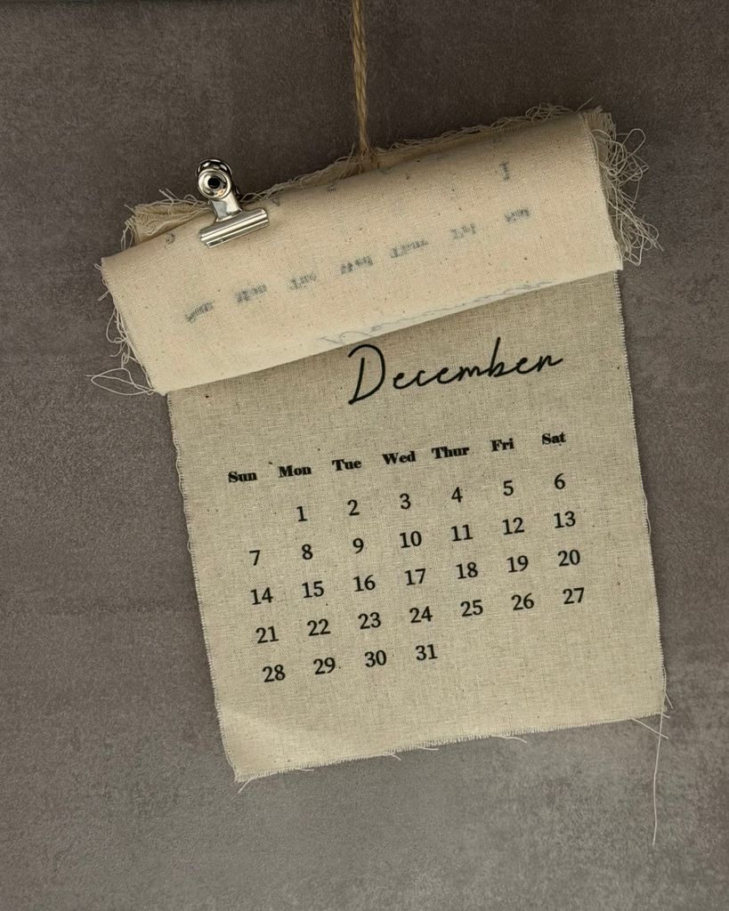 A vintage-style hanging calendar page displaying December dates, ideal for home decor.